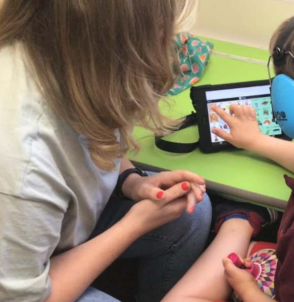 Megan supporting a child using a communication app on a tablet